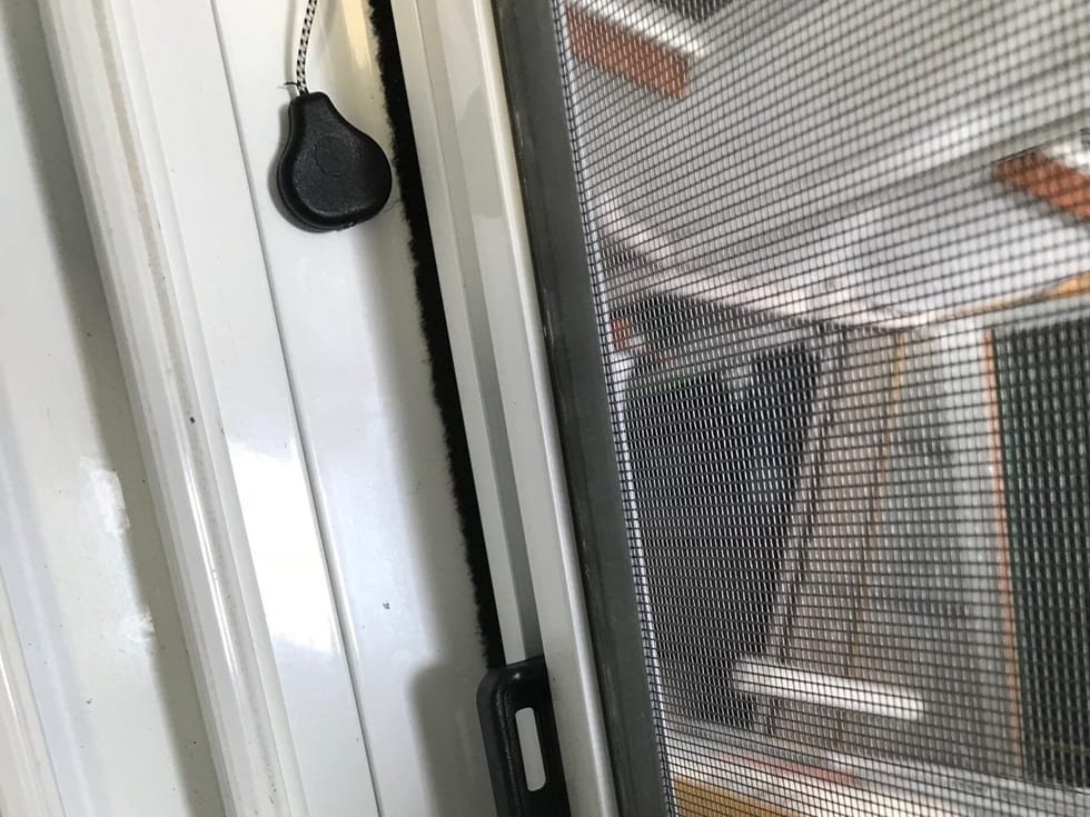 Detalle del cajón y la guía de una mosquitera enrollable